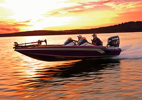 Fishermen speeding along the water at sunset